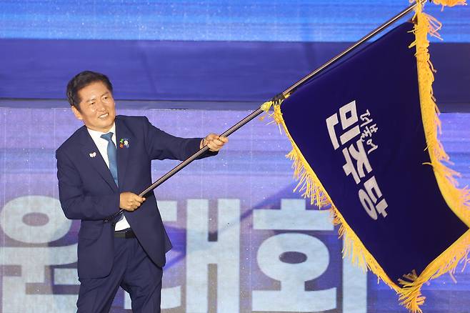 Newly-elected Democratic Party leader Jung Chung-rae waves the party flag during the party’s national convention at Kintex in Goyang, Gyeonggi, on Aug. 2.  [YONHAP]