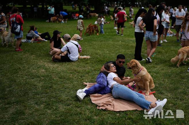 [부에노스아이레스=AP/뉴시스] 8일(현지 시간) 아르헨티나 부에노스아이레스 팔레르모 공원에서 열린 세계에서 가장 많은 골든 리트리버가 한자리에 모이는 세계 기록 도전 행사에 참가한 참가자들이 반려견과 즐거운 시간을 보내고 있다. 2025.12.09.