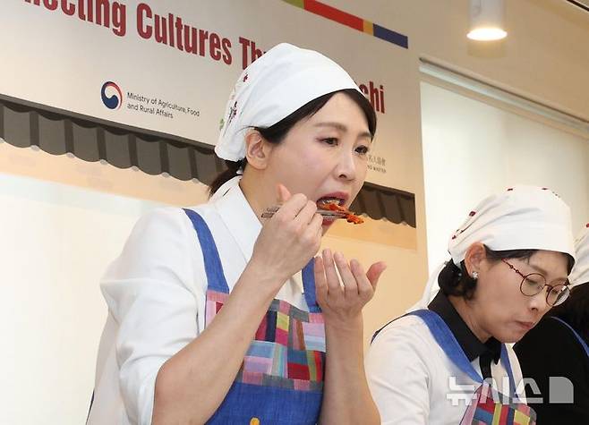 [서울=뉴시스] 고범준 기자 = 김혜경 여사가 9일 서울 종로구 북촌 한식문화공간 이음에서 열린 주한대사 배우자 초청 김장 행사에서 김치를 시식하고 있다. 2025.12.09. bjko@newsis.com