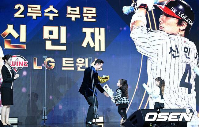 [OSEN=조은정 기자] 9일 오후 서울 송파구 잠실동 롯데호텔 월드에서 2025 신한은행 SOL 뱅크 KBO 골든글러브 시상식이 열렸다.KBO 골든글러브 시상식은 포지션별 최고의 선수를 가리는 자리로 올 시즌의 대미를 장식하는 자리다.&nbsp;2루수 부문을 수상한 LG 신민재가 딸에게 꽃다발을 받고 있다. 2025.12.09 /cej@osen.co.kr