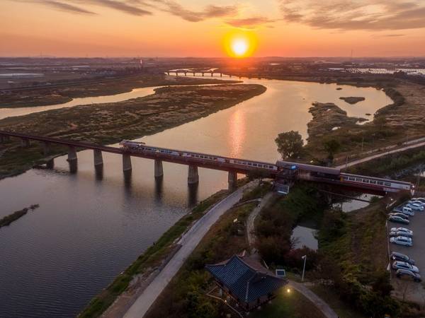 비비정에서 바라본 옛 철길에 놓인 예술 열차가 석양 속 한 폭의 동양화를 연출하고 있다. /완주군 제공