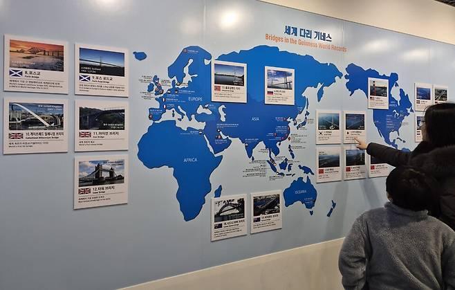 ▲&nbsp;인천 중구 인천대교 기념관에서 방문객들이 인천대교가 포함된 세계 다리 기네스 현황판을 살펴보고 있다. /박범준 기자 parkbj2@incheonilbo.com