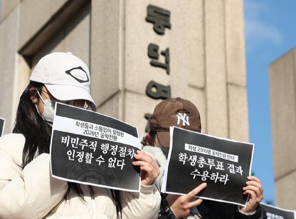 지난 9일 서울 성북구 동덕여자대학교 정문에서 열린 '2025 학생총투표 결과 전달 기자회견'에서 학생들이 공학 전환에 반대하는 내용의 손팻말을 들고 있다. [사진=연합뉴스]