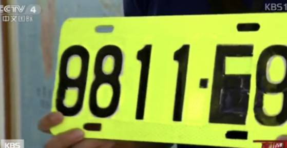 A specialized yellow-green license plate is displayed before being attached to drunk drivers' vehicles in Taiwan in a footage aired by CCTV and Korean broadcaster KBS. [SCREEN CAPTURE]