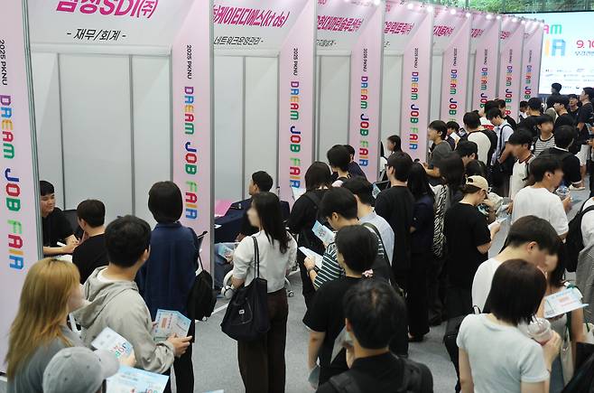 Job seekers speak with corporate recruiters at a job fair at Pukyong National University in Busan on Sept. 10. [YONHAP]