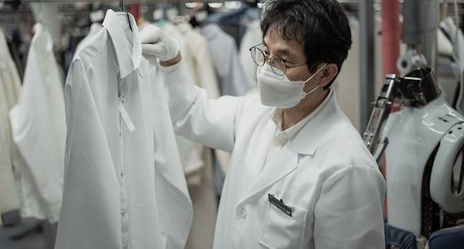 워시스왓이 운영하는 세탁특공대 프리미엄 전문 센터에서 검수 직원이 의류 상태를 점검하고 있다. 워시스왓