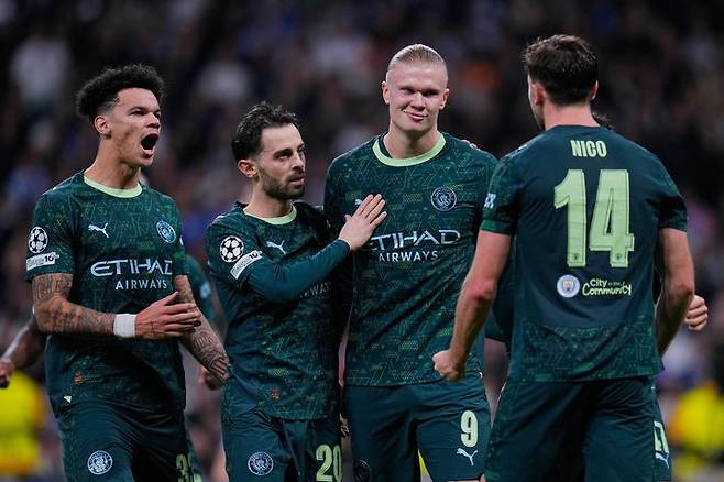 [마드리드=AP/뉴시스] 맨체스터 시티(잉글랜드)의 엘링 홀란(오른쪽 두 번째)이 10일(현지 시간) 스페인 마드리드의 에스타디오 산티아고 베르나베우에서 열린 2025-26 유럽축구연맹(UEFA) 챔피언스리그(UCL) 리그 페이즈 6차전 레알 마드리드와 경기 전반 43분 페널티킥(PK)으로 역전 골을 넣고 동료들과 함께 기뻐하고 있다. 맨시티가 2-1로 승리하고 5위를 기록했다. 2025.12.11.