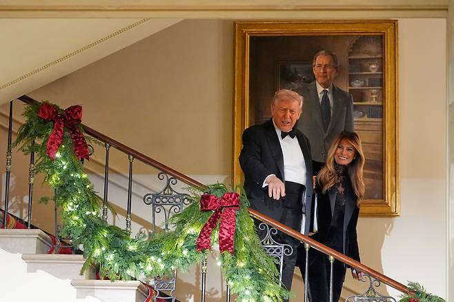 도널드 트럼프 대통령과 멜라니아 트럼프 여사가  11일(현지시각) 미국 워싱턴에서 열린 의회 무도회(Congressional Ball)에서 백악관 그랜드 포이어(Grand Foyer)로 내려가던 중 조지 W. 부시 전 대통령의 초상화 옆을 지나가고 있다./AP연합뉴스