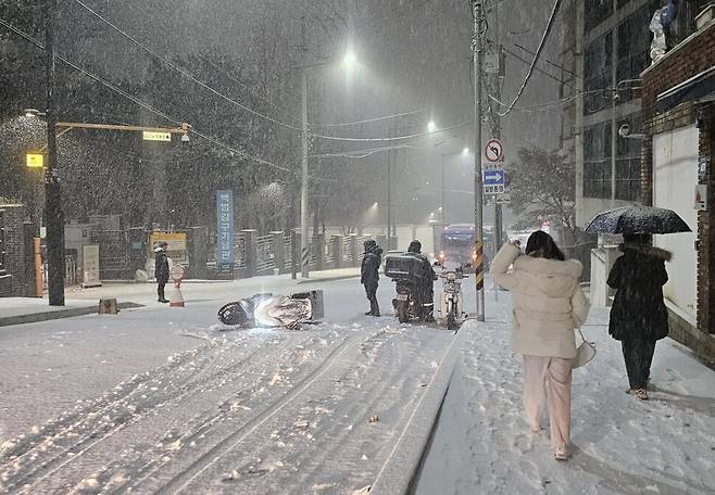 서울·인천·경기·강원 등 4개 시도에 대설특보가 발효된 4일 서울 용산구 효창동에서 눈이 쌓인 길을 지나던 오토바이가 넘어져있다. 유정아 기자 verano@hani.co.kr