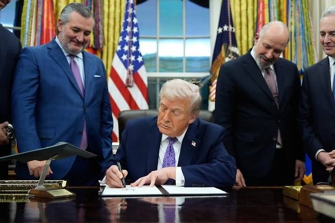 도널드 트럼프 미국 대통령(가운데)이 2025년 12월 11일(현지시간) 워싱턴 백악관 집무실에서 인공지능(AI) 관련 행정명령에 서명하고 있다. 왼쪽은 테드 크루즈 상원의원(텍사스·공화당), 오른쪽 두 번째는 하워드 루트닉 상무장관, 오른쪽은 데이비드 삭스 백악관 인공지능·가상화폐 담당 보좌관. AP 연합뉴스