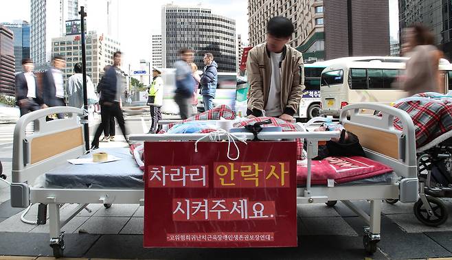 2018년 10월10일 서울 중구 태평로 덕수궁 대한문 앞에서 고위험 희귀난치 근육장애인생존권 보장연대 회원이 침대에 누워 인공호흡기에 의지한 채 활동지원사 근무 시간이 줄어든 것에 항의하며 행진을 준비하고 있다. ⓒ연합뉴스