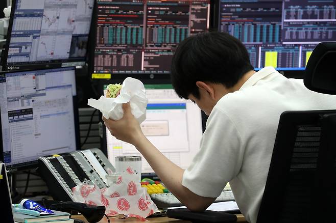 샌드위치를 먹으며 업무를 보고 있는 직장인. [사진 | 뉴시스]