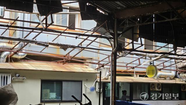 12일 인천 미추홀구 제일시장. 지붕을 이루던 석면판이 아슬하게 걸려있는 가운데, 바로 밑에서 상인이 장사하고 있다. 박기웅기자