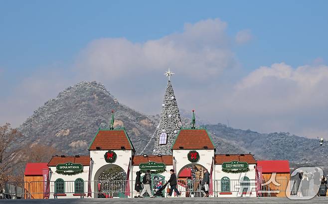 성탄절을 열흘 여 앞둔 14일 오후 서울 종로구 광화문광장을 찾은 시민들이 눈 덮인 북악산을 배경으로 겨울동화 속 산타마을 콘셉트로 꾸며진 크리스마스 광화문 마켓을 둘러보고 있다. 2025.12.14/뉴스1 ⓒ News1 오대일 기자
