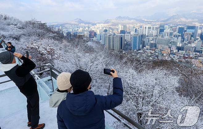 지난 밤 내린 눈이 쌓인 14일 서울 용산구 남산공원을 찾은 시민들이 겨울풍경을 만끽하고 있다. 2025.12.14/뉴스1 ⓒ News1 이호윤 기자