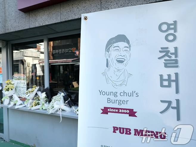 14일 오전 서울 성북구 안암동 영철버거 앞에 영철버거 대표 이영철 씨의 별세 소식을 추모하는 꽃이 놓여져 있다. '고려대 명물'로 통하는 '영철버거' 대표 이 씨는 지난 13일 별세했다. 향년 58세. 고인은 암 투병 중이었던 것으로 알려졌다. 2025.12.14/뉴스1 ⓒ News1 황기선 기자
