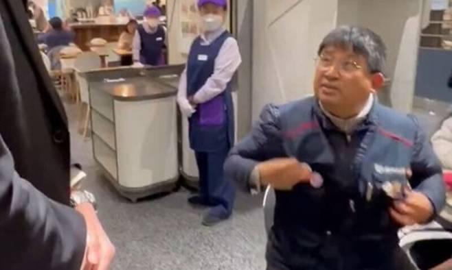 이김춘택 금속노조 거제·통영·고성 조선하청지회 사무장이 지난 10일 롯데백화점 잠실점에서 노조 조끼 탈의를 요구하는 보안요원에 항의하고 있다. 엑스(X) 캡처
