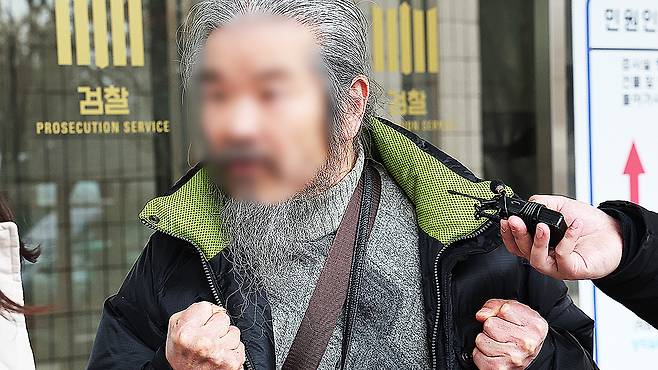 Convicted child rapist Cho Doo-soon answers questions from reporters after attending his first trial hearing at the Suwon District Court’s Ansan branch in Ansan, Gyeonggi, on March 11, 2024. [YONHAP]