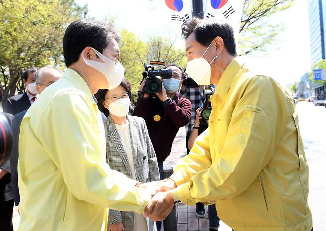오세훈 서울시장이 지난 2021년 서울 성동구청에 마련된 서울시 1호 예방접종센터를 방문해 정원오 성동구청장과 악수하고 있다. 연합뉴스