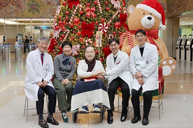 서울아산병원 장기이식센터 폐이식팀 의료진이 300번째 폐이식 환자(가운데)의 성공적인 수술과 회복을 축하하며 9일(화) 기념사진을 찍고 있다.