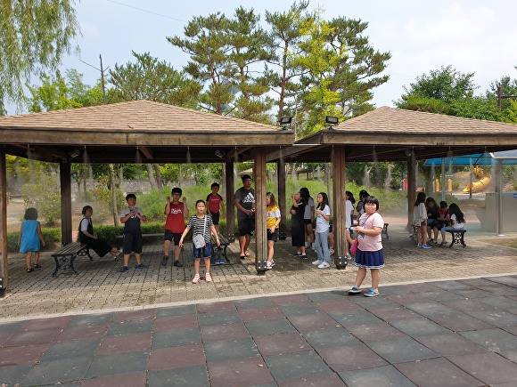 진천군의 폭염 예방 쿨링포그 시설에서 아동들이 쉬고 있다. [사진=진천군]