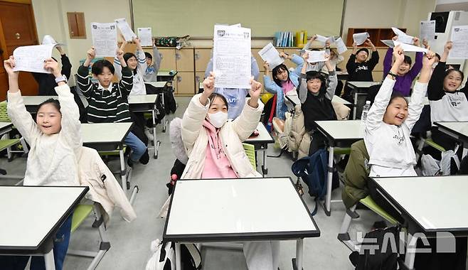 [수원=뉴시스] 김종택 기자 = 겨울방학식이 열린 16일 경기 수원시 영통구 잠원초등학교에서 4학년8반 학생들이 방학안내문을 들어보이고 있다. 2025.12.16. jtk@newsis.com