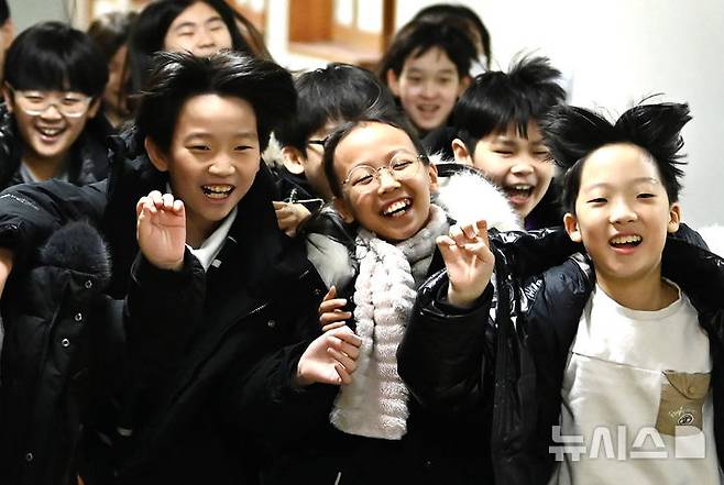 [수원=뉴시스] 김종택 기자 = 겨울방학식이 열린 16일 경기 수원시 영통구 잠원초등학교에서 4학년8반 학생들이 환하게 웃으며 하교하고 있다. 2025.12.16. jtk@newsis.com