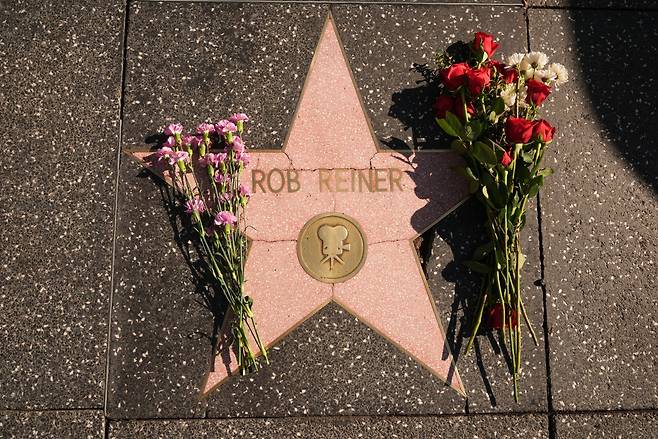 Flowers cover the Walk of Fame star for Rob Reiner Monday, Dec. 15, 2025, in the Hollywood section of Los Angeles. (AP Photo/Damian Dovarganes)