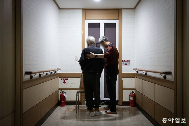 지난달 19일 요양원을 배회하는 치매 환자를 요양보호사가 병실로 인도하고 있다. 전국의 치매 환자 약 31만 명이 요양시설에서 지내고 있다.