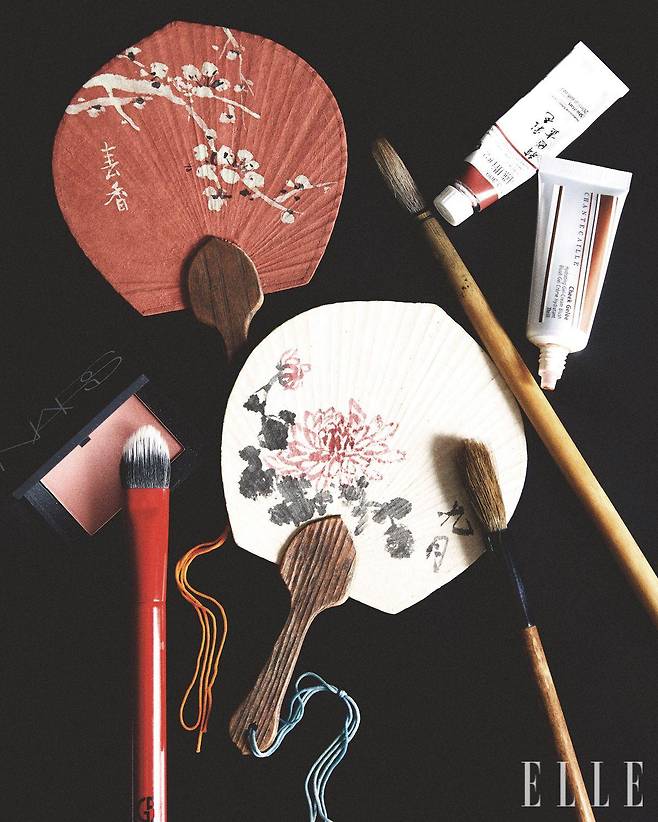 어머니와 함께 그린 수채화가 담긴 부채와 붓, 물감은 늘 무궁무진한 영감을 준다. 함께 세팅된 제품은 치크 젤리, 쓰릴, 8만3천원, Chantecaille. 치크 브러시, 가격 미정, Armani Beauty. 나스 블러쉬, 돌체 비타, 4만9천원대, Nars.