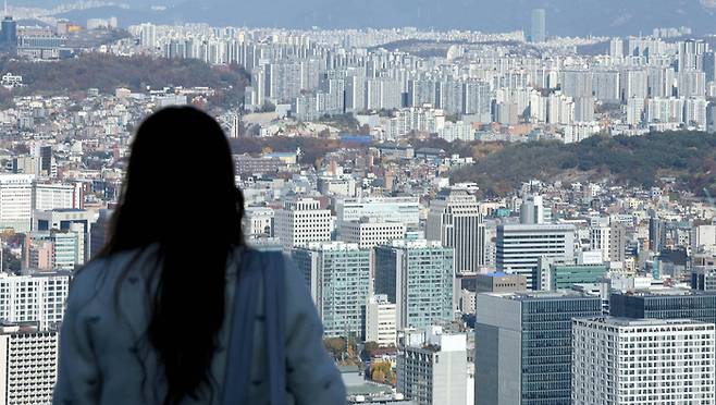 서울 중구 남산에서 한 청년이 아파트 단지들을 바라보고 있다. [뉴스1]