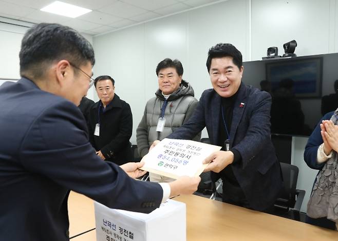 박준희(오른쪽) 서울 관악구청장이 지난 15일 기획재정부를 찾아 난곡선 경전철의 예비타당성조사 경제성 개선 방안에 대한 주민 동의서를 전달하고 있다. 관악구 제공