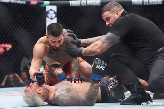 일리아 토푸리아(왼쪽 위)가 찰스 올리베이라(아래)에게 파운딩을 시도하고 있다. /AFPBBNews=뉴스1