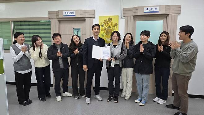 ▲ '2025년 e아동행복지원사업 우수사례 공모전'에서 최고 등급인 대상을 수상한 박소연 주무관(왼쪽에서 여섯번째)을 구미시 형곡2동 행정복지센터 강명천 동장을 비롯한 직원들이 축하하고 있다.