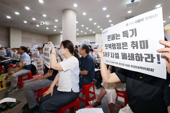 지난 8월 광주 남구 양과동 광역위생 매립장 내 가연성폐기물 연료화시설(SRF)에서 열린 악취 해결을 위한 간담회에서 주민들이 손팻말을 들고 구호를 외치고 있다. 연합뉴스.