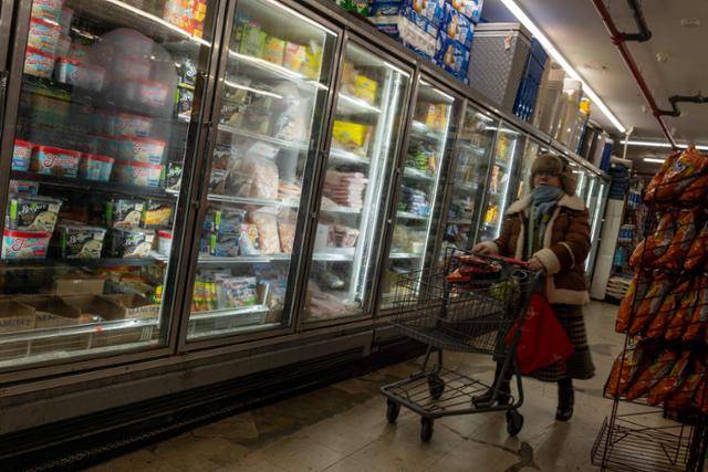 12일 미국 뉴욕의 한 식료품 상점에서 한 시민이 장을 보고 있다. 뉴욕=AFP 연합뉴스