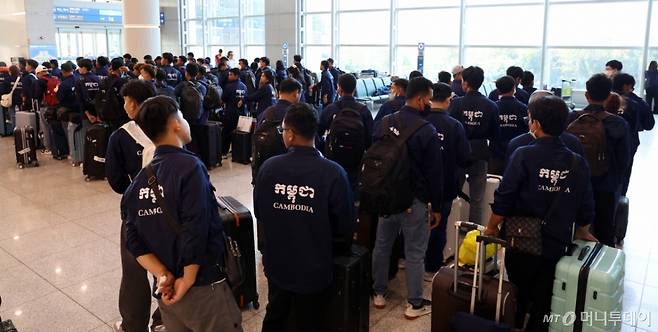 (인천공항=뉴스1) 김명섭 기자 = 27일 오전 인천공항에서 E9비자로 입국한 캄보디아 노동자들이 이동을 하기위해 줄지어 기다리고 있다.   E-9 비자는 한국의 사업주에게 외국인근로자의 고용을 허가하는 제도이다.  E9 비자를 통해 외국인 근로자들은  체류기간은 3년이고 재고용 1회( 4년 10개월) 동안 일할 수 있다. 2025.5.27/뉴스1  Copyright (C) 뉴스1. All rights reserved. 무단 전재 및 재배포,  AI학습 이용 금지. /사진=(인천공항=뉴스1) 김명섭 기자
