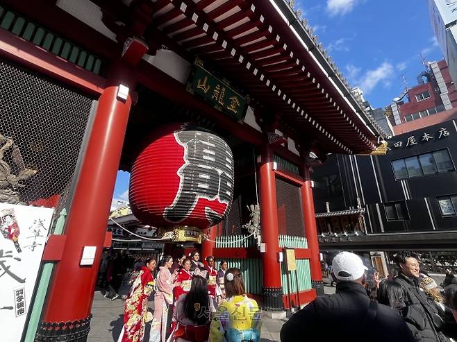 17일 일본 도쿄 아사쿠사 센소지 입구에 위치한 붉은 등 ‘가미나리몬’을 배경으로 기모노를 입은 외국인 관광객들이 사진을 찍고 있다.