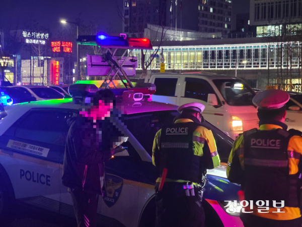 18일 저녁 경기남부경찰청이 수원시청역 인근 도로에서 음주단속을 진행하는 모습. 단속에 적발된 남성이 경찰에 조사를 받고 있다. 2025.12.18 /고건기자 gogosing@kyeongin.com