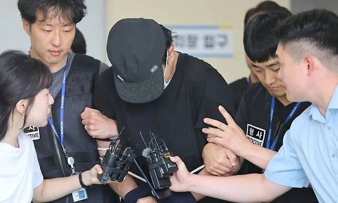 울산의 한 병원 주차장에서 20대 여성에게 흉기를 휘둘러 살해하려 한 혐의(살인미수)로 경찰에 체포된 장형준씨가 지난 7월30일 울산지방법원의 구속 전 피의자심문(영장실질심사)에 출석하기 위해 호송차로 이동하고 있다. 연합뉴스