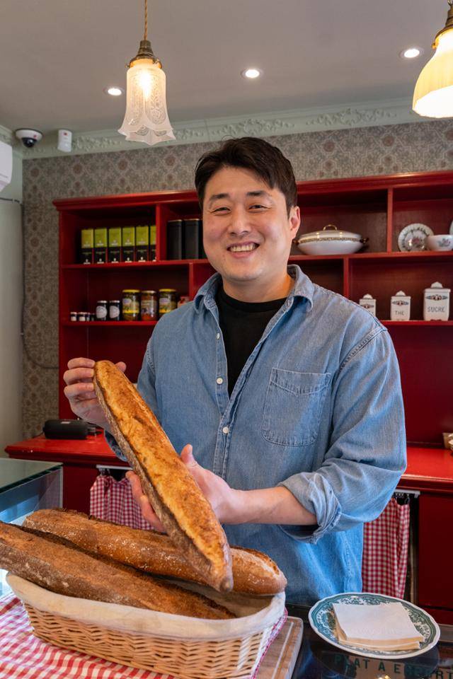 이성대 셰프가 매장에서 바게트를 들어 보이고 있다.
