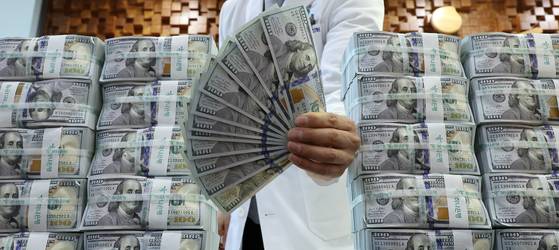 원/달러 환율이 외국인 투자자의 국내 주식 매도 등의 영향으로 추가 상승해 장중 1,480원을 넘은 17일 서울 중구 하나은행 위변조대응센터에서 직원이 달러화를 정리하고 있다.   외환 당국은 최근 국민연금과 맺은 외환스와프를 실제 가동한 것으로 알려졌다. 연합뉴스