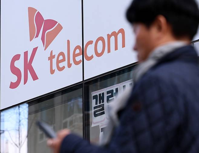 서울 시내에 위치한 SK텔레콤 대리점 앞으로 한 시민이 지나가고 있다. [사진 = 뉴스1]