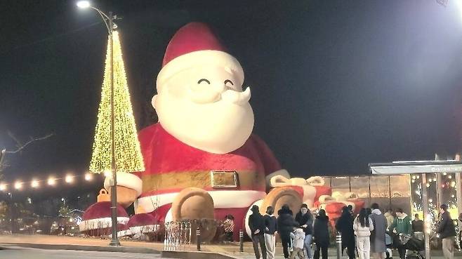 지난 20일 ‘별빛 산타 레이크' 점등식이 열린 송해공원 입구에 설치된 초대형 산타 앞에서 기념 촬영을 위해 줄을 선 방문객들.