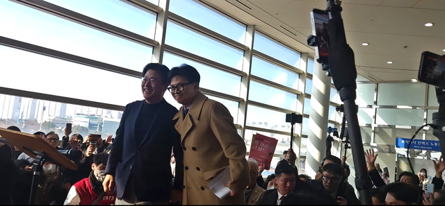 한동훈(오른쪽) 국민의힘 전 당대표가 21일 오후 경기 고양시 일산 킨텍스에서 토크콘서트를 마친 뒤, 행사장 입장권 없이도 자신을 직접 보기 위해 모여든 지지자들을 잠시 만나 격려 발언한 뒤 김종혁(왼쪽) 전 최고위원을 응원하며 함께 포즈를 취하고 있다.<유튜브 채널 ‘후니도토리’ 중계 영상 갈무리>