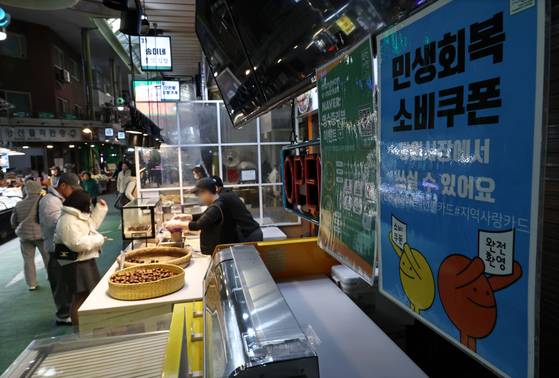 올해 3분기 소상공인의 매출이 정부의 민생회복 소비쿠폰 효과로 늘었지만 고물가로 비용지출도 같이 늘면서 이익은 전 분기보다 오히려 줄어든 것으로 나타났다. 사진은 서울 마포구 망원시장 상점에 붙은 민생회복 소비쿠폰 안내문 모습. 연합뉴스