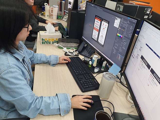 조승민 매니저가 스마트건설안전산업전 초청장을 제작 중이다. 윤현주 기자