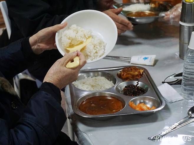 19일 오전 서울 동대문구 밥퍼나눔운동본부에서 점심 식사를 배식받은 한 어르신이 쌀밥을 추가하고 있다. 노유지 기자