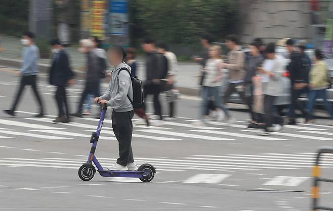 2023년 10월 26일 오후 서울 서대문구 연세대학교 신촌캠퍼스 앞 횡단보도에서 한 남성이 전동 킥보드를 타고 길을 건너고 있다. /조선DB