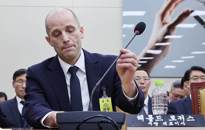Harold Rogers, interim chief of Coupang in Korea, adjusts the microphone during a parliamentary hearing held at the National Assembly in western Seoul on Dec. 17. [LIM HYUN-DONG]